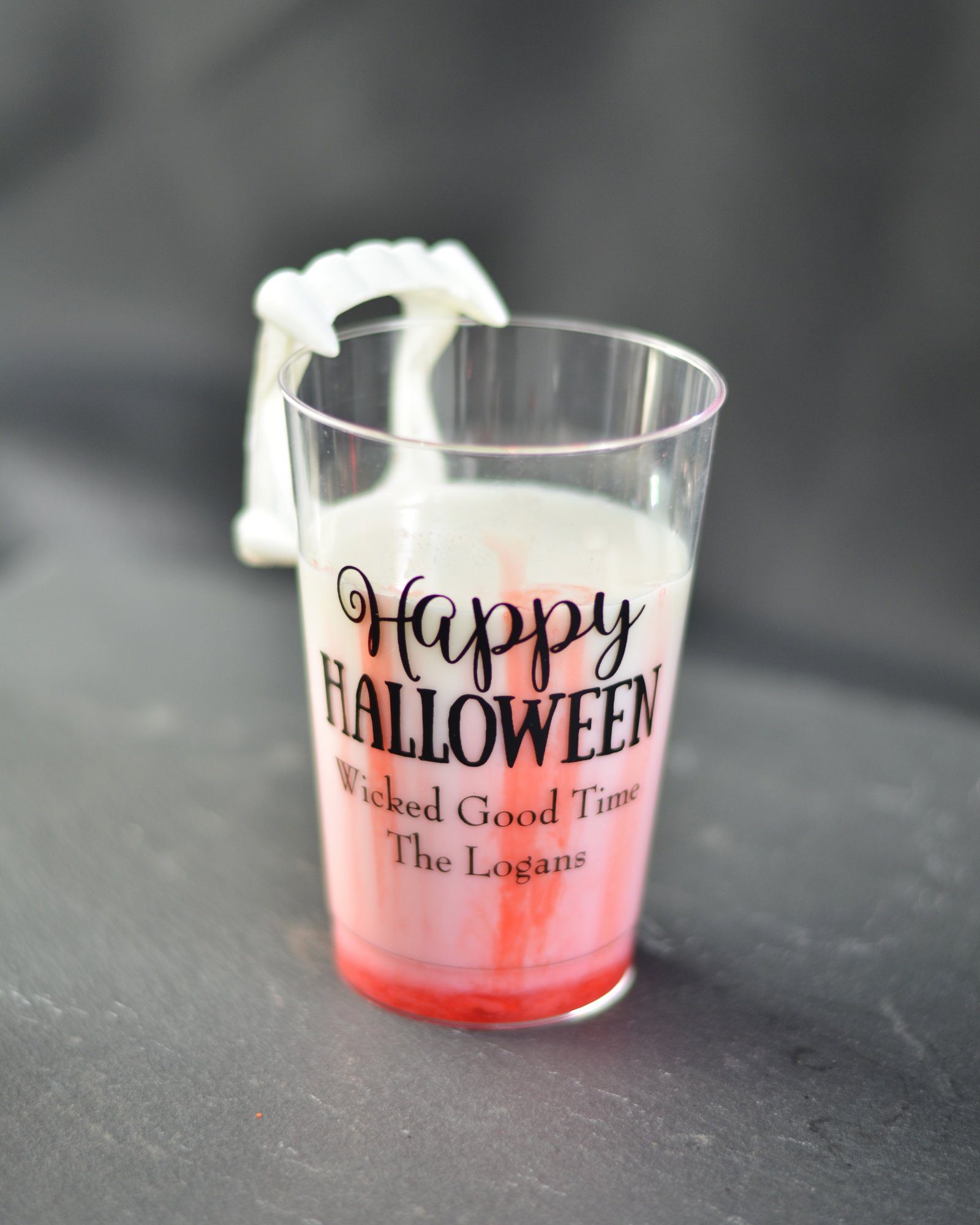 Kids Halloween drink with milk and strawberry syrup called vampires bite in a personalized Halloween cup. 